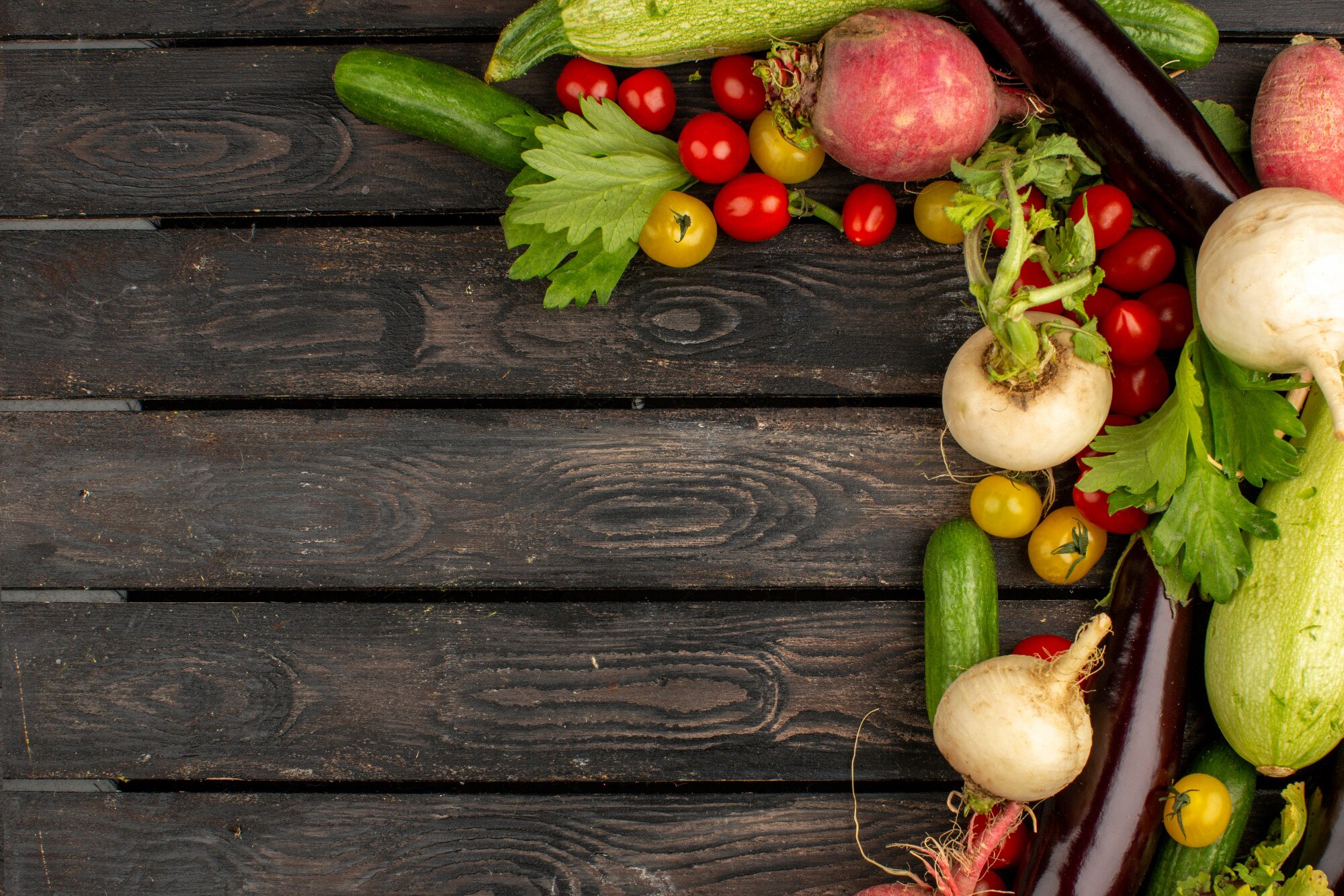 Variedad de verduras frescas de temporada dispuestas sobre una mesa de madera